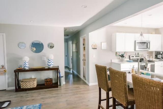 dining area with light wood-style floors and baseboards
