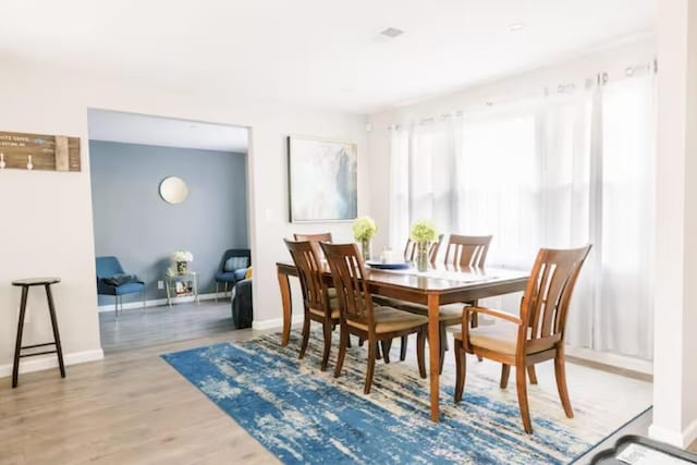 dining space featuring wood finished floors and baseboards