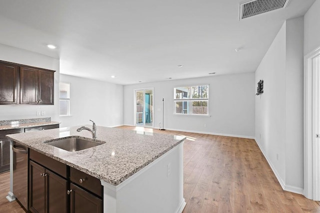 261 Celestial Blvd, Summerville, SC 29486 - kitchen featuring a sink, dishwasher, dark brown cabinets, an island with sink, and light stone counters