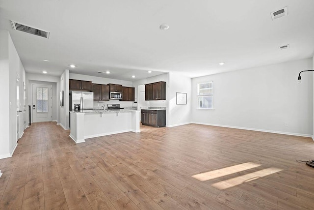 261 Celestial Blvd, Summerville, SC 29486 - unfurnished living room with light wood-type flooring, baseboards, recessed lighting, and a sink
