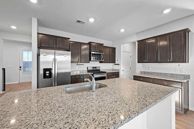 261 Celestial Blvd, Summerville, SC 29486 - kitchen with appliances with stainless steel finishes, a sink, dark brown cabinets, light wood-type flooring, and recessed lighting