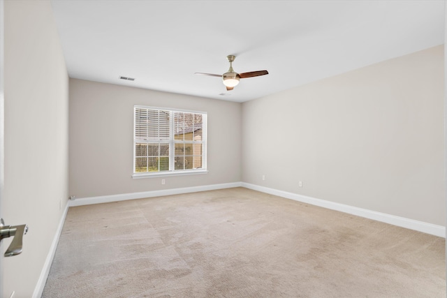 spare room featuring carpet, visible vents, ceiling fan, and baseboards