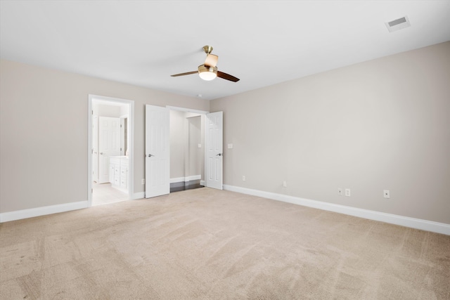 unfurnished bedroom with visible vents, baseboards, a ceiling fan, connected bathroom, and light colored carpet