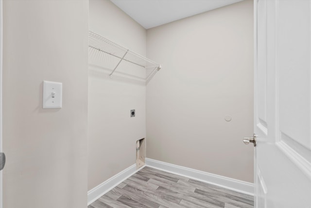 washroom with baseboards, laundry area, light wood-style flooring, and hookup for an electric dryer