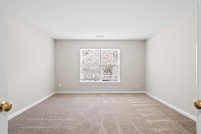 carpeted empty room with visible vents and baseboards