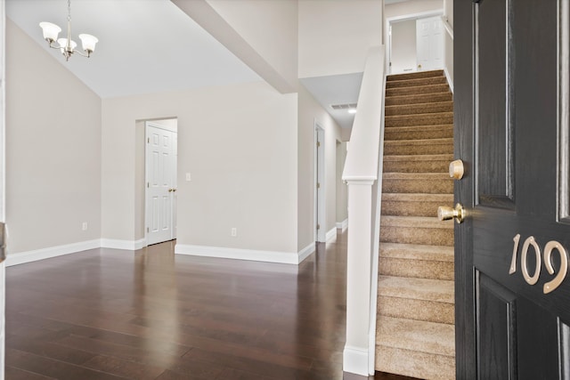 entryway with a notable chandelier, baseboards, and dark wood-type flooring