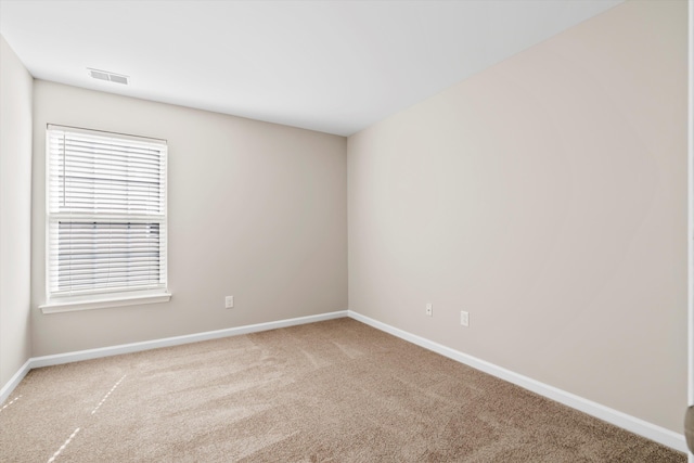 carpeted empty room featuring visible vents and baseboards