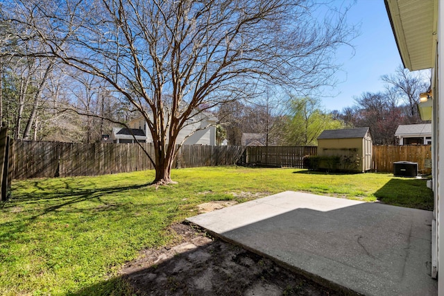 view of yard with an outbuilding, a fenced backyard, a patio, and a shed