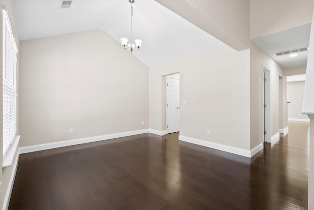 spare room with vaulted ceiling, dark wood finished floors, visible vents, and baseboards