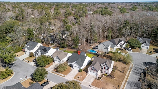 drone / aerial view featuring a residential view and a view of trees