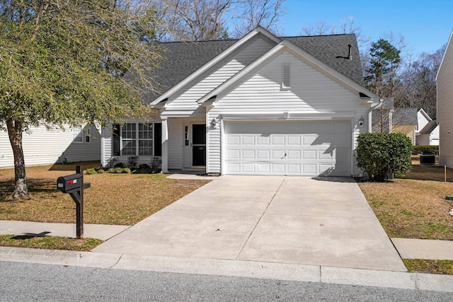 view of front of home with concrete driveway, a shingled roof, a front lawn, and an attached garage