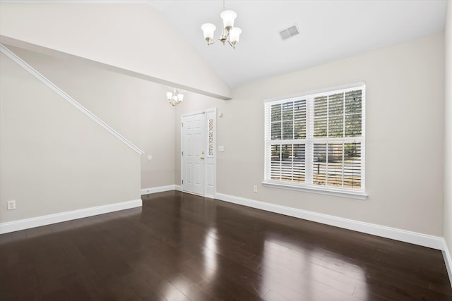 entrance foyer with a chandelier, lofted ceiling, wood finished floors, visible vents, and baseboards