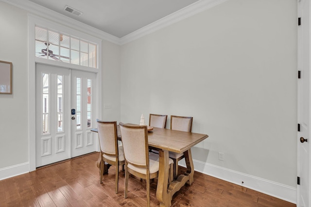 dining area with crown molding, ceiling fan, and wood-type flooring