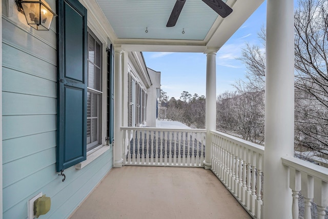 snow covered back of property featuring ceiling fan