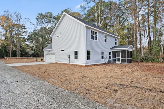 view of property exterior featuring a garage, central AC unit, and a sunroom