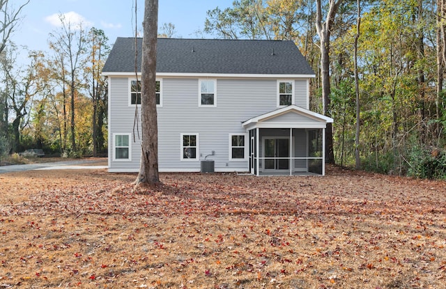 rear view of property featuring a sunroom and cooling unit