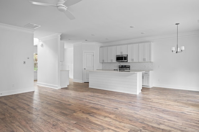 unfurnished living room featuring ceiling fan with notable chandelier, sink, light wood-type flooring, and crown molding