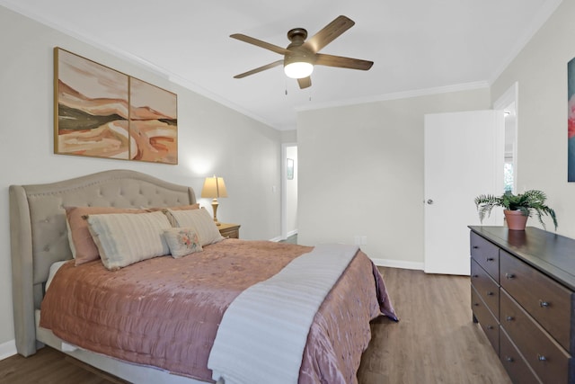 bedroom with ceiling fan, baseboards, wood finished floors, and ornamental molding