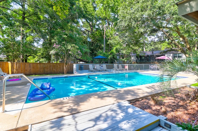 community pool featuring a patio and fence