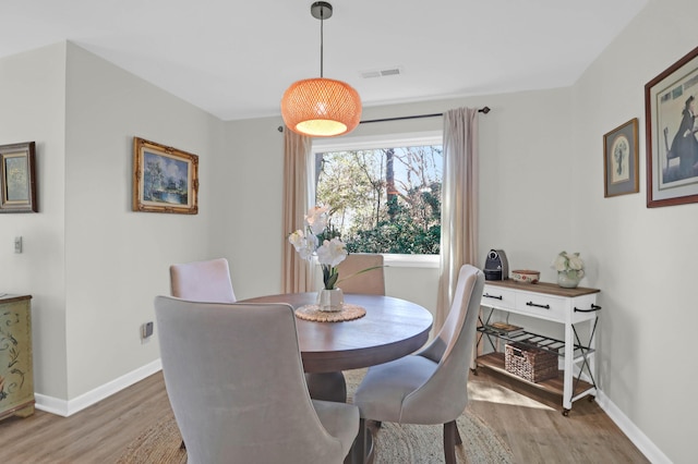 dining room with visible vents, light wood-style flooring, and baseboards