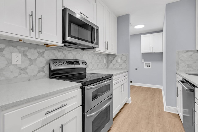 kitchen featuring light hardwood / wood-style floors, white cabinetry, stainless steel appliances, and tasteful backsplash