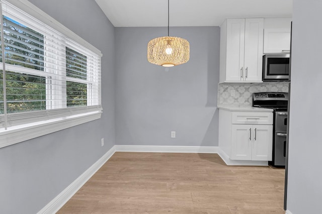 kitchen with white cabinets, appliances with stainless steel finishes, backsplash, and decorative light fixtures