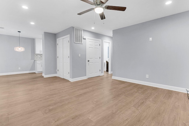 unfurnished living room with ceiling fan and light hardwood / wood-style flooring