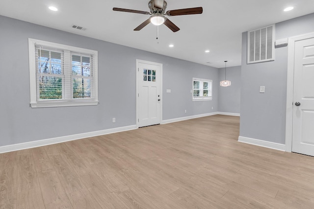 unfurnished living room featuring ceiling fan and light wood-type flooring