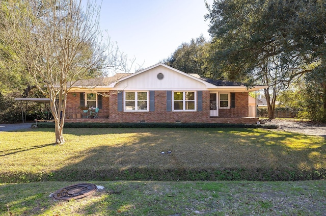 view of front facade with an outdoor fire pit, brick siding, and a front yard