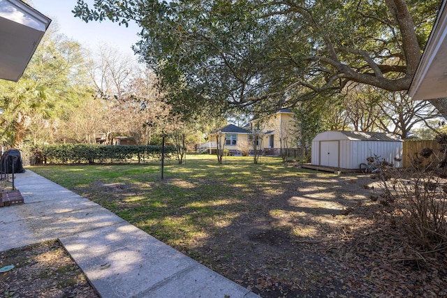 view of yard featuring a shed, a fenced backyard, and an outdoor structure