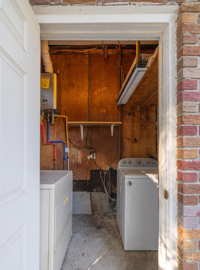 washroom with washer / dryer, brick wall, laundry area, and tankless water heater