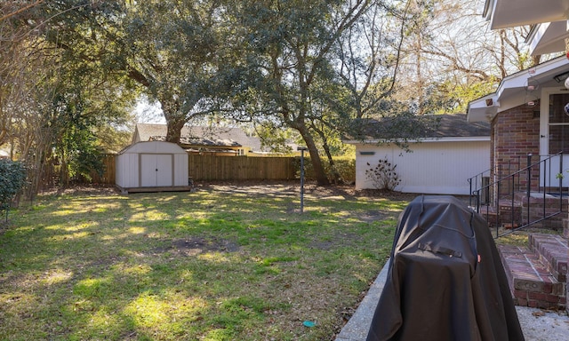 view of yard with a fenced backyard, a storage unit, and an outdoor structure