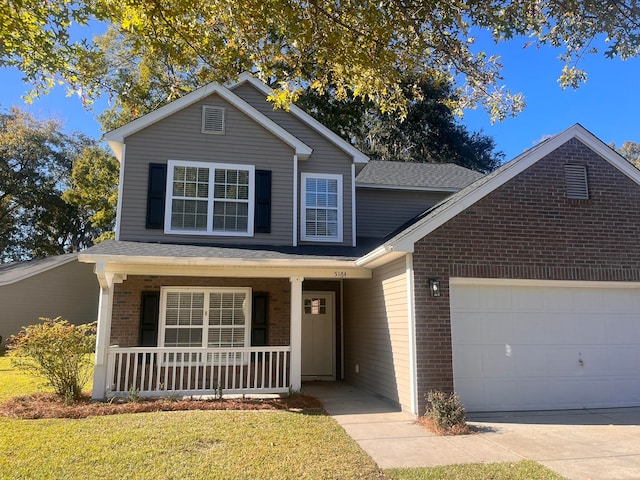 front of property featuring covered porch, a garage, and a front lawn