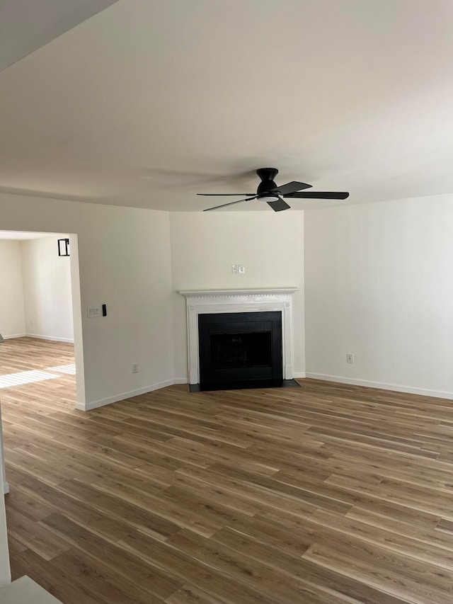 unfurnished living room with ceiling fan and dark wood-type flooring