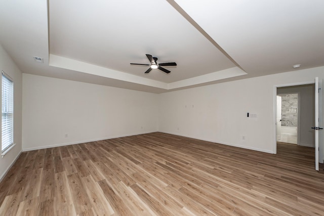 unfurnished room with a wealth of natural light, ceiling fan, and light hardwood / wood-style floors