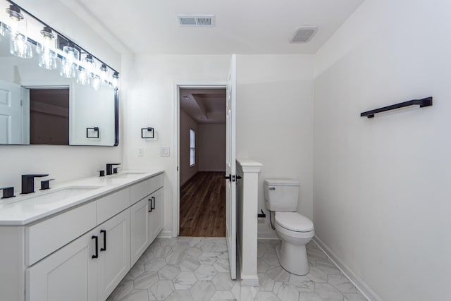 bathroom featuring hardwood / wood-style floors, vanity, and toilet