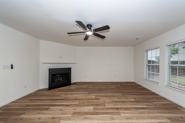 unfurnished living room featuring light hardwood / wood-style flooring, ceiling fan, and a healthy amount of sunlight