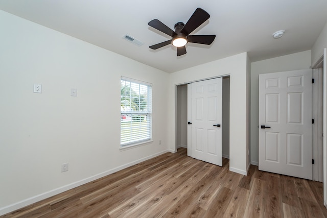 unfurnished bedroom with ceiling fan, a closet, and light hardwood / wood-style floors