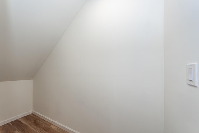 additional living space with wood-type flooring and lofted ceiling