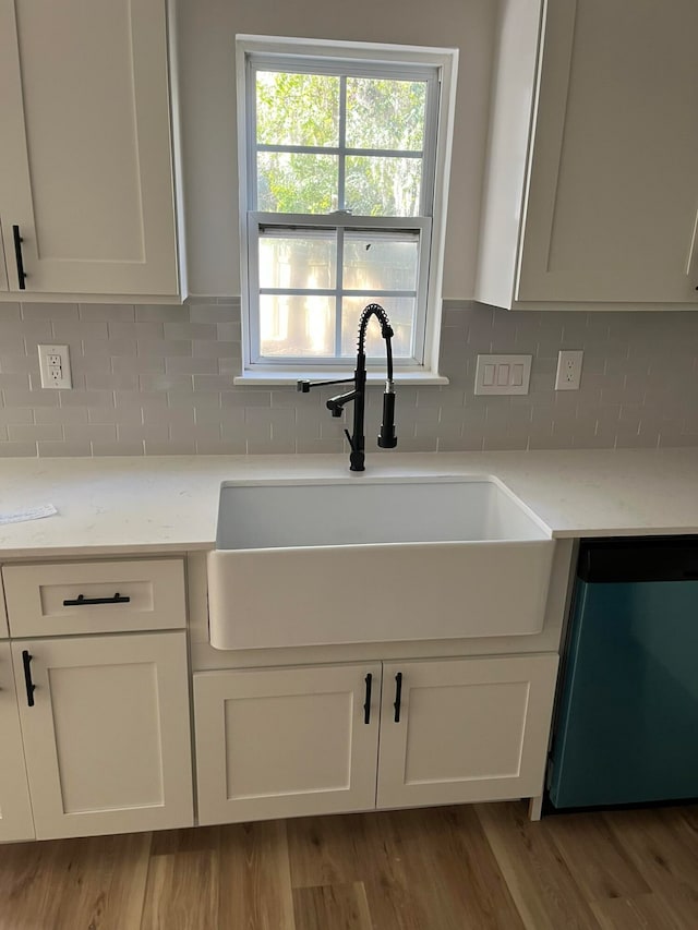 kitchen featuring dishwasher, white cabinetry, and sink