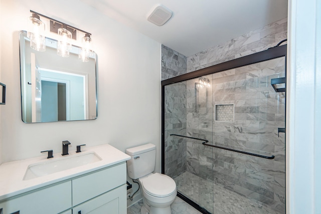 bathroom featuring vanity, toilet, and a shower with shower door