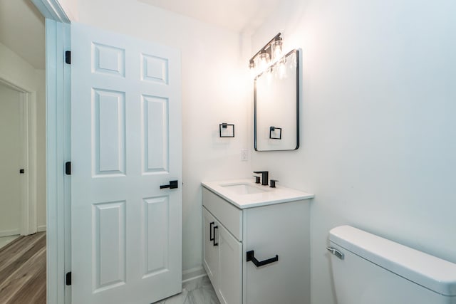 bathroom with hardwood / wood-style floors, vanity, and toilet