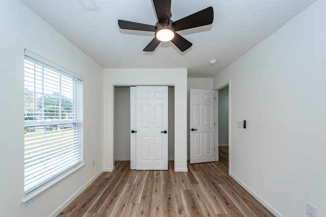 unfurnished bedroom featuring a closet, light hardwood / wood-style flooring, and ceiling fan