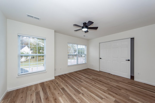 unfurnished bedroom with ceiling fan, a closet, and hardwood / wood-style flooring