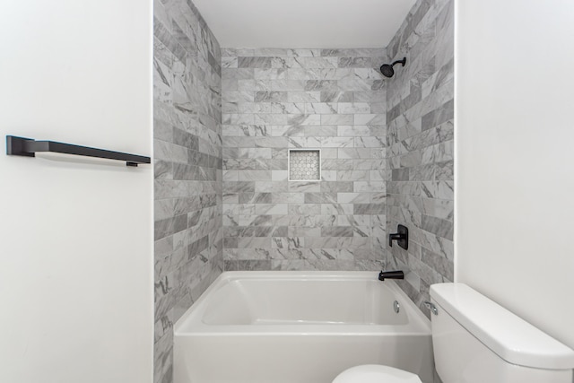 bathroom featuring toilet and tiled shower / bath