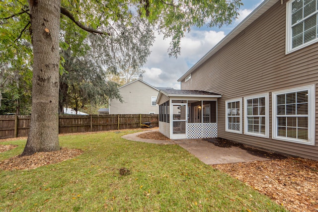 view of yard with a sunroom and a patio