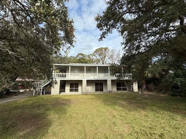 back of property featuring a yard and a wooden deck