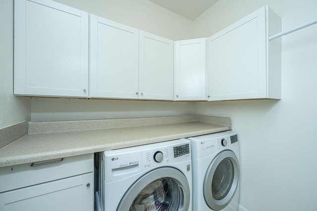 washroom featuring cabinets and washer and dryer