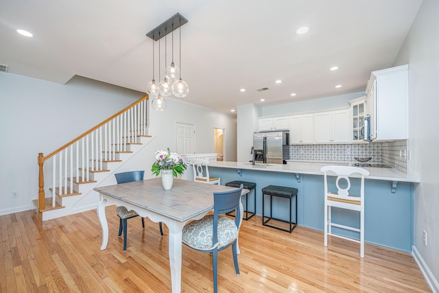 dining space featuring sink and light wood-type flooring