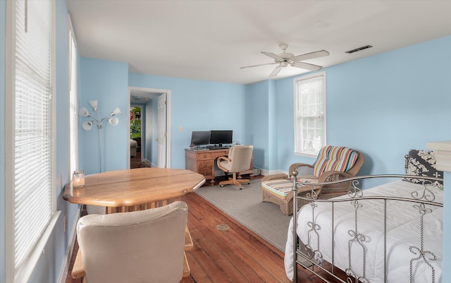 bedroom featuring multiple windows, ceiling fan, and hardwood / wood-style flooring